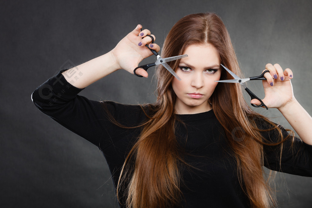 优雅的女人展示了她的美发沙龙专业优雅的女理发师用剪刀