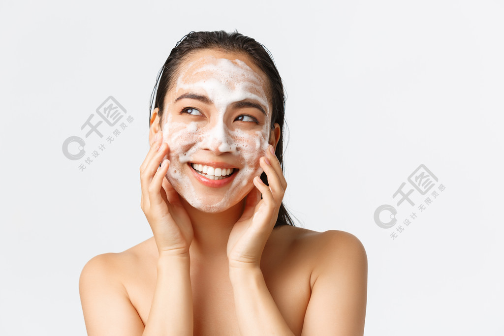 护肤、女性美容、卫生和个人护理概念。美丽的裸体亚洲女性的特写镜头微笑着，看起来很乐观，同时用清洁泡沫、日常护理产品清洁皮肤。护肤、女性美容、卫生和个人护理概念。用清洁泡沫、日常护理产品清洁皮肤时，美丽