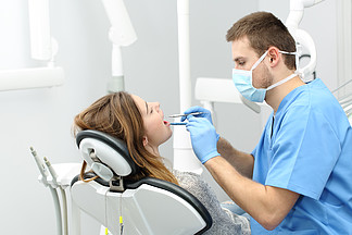 快乐的牙医为<i>病</i><i>人</i>做牙齿卫生