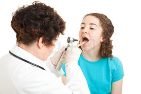 十几岁的女孩张开嘴，让医生检查她的喉咙。在白色上隔离。