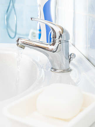 金属<i>浴</i><i>室</i>清洁水槽水龙头、肥皂条和口腔卫生必需品、电动牙刷。<i>浴</i><i>室</i>水槽、肥皂和电动牙刷