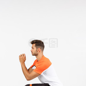 垂直剖面射击运动员将深蹲作为双腿之间的安全阻力绳，用膝盖拉伸环，将双臂抱在一起，在主动训练期间尝试保持健康，白色背景。垂直剖面射击运动员将深蹲作为双腿之间的安全阻力绳，拉伸环膝盖，双臂紧握在一起，在积