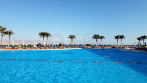 夏日酒店海滩度假村美丽的室外游泳池在蓝天映衬下的照片。夏日酒店海滩度假村美丽的室外游泳池在蓝天映衬下的形象