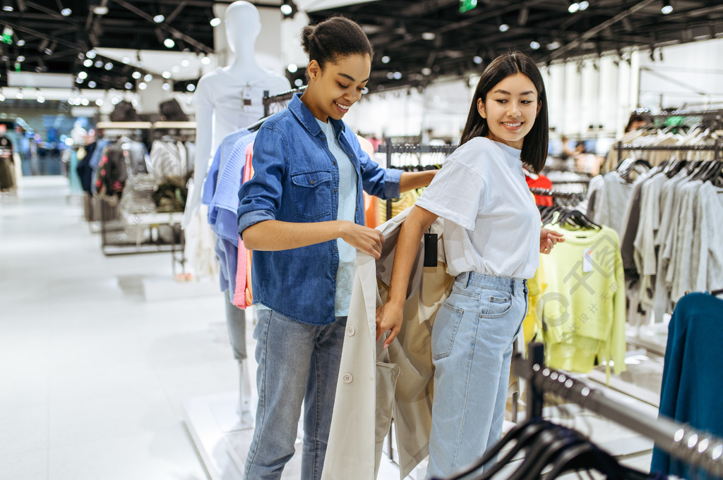 两个女孩在服装店试穿外套在时尚精品店购物的女性购