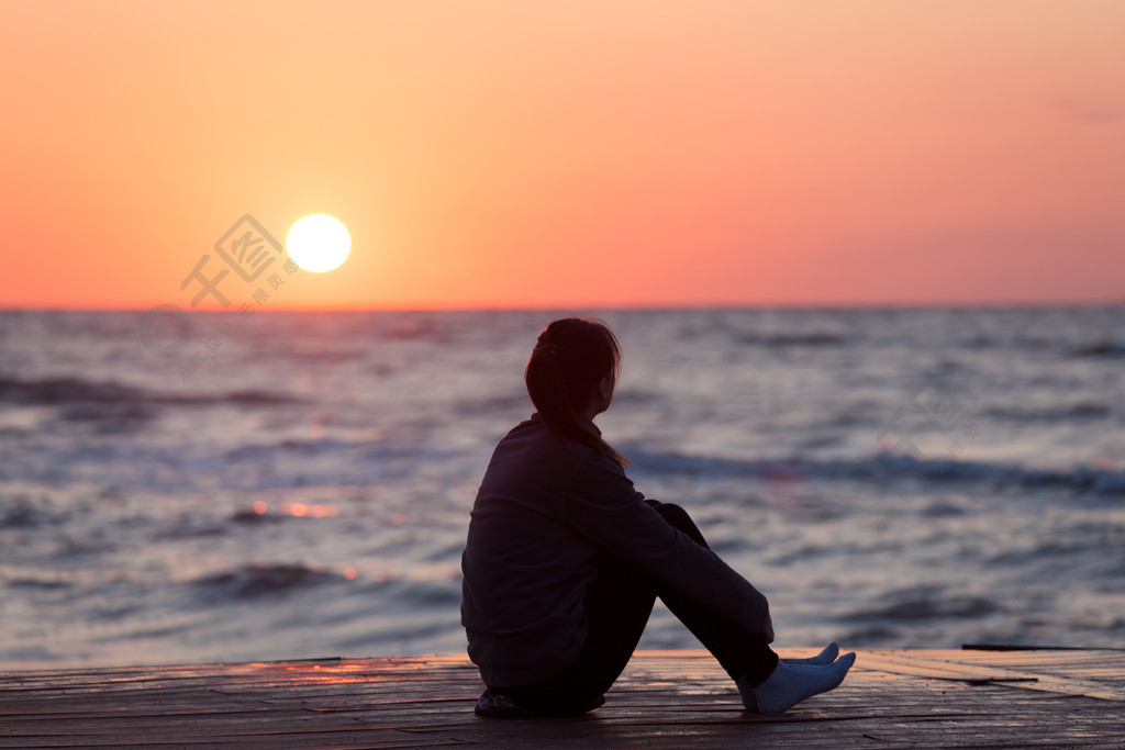 一个人坐在海边的背影图片