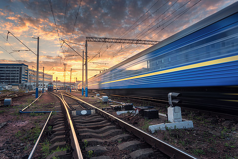 高速旅客列車在日落時在鐵軌上行駛.