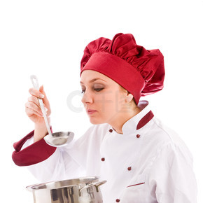 拿着锅的女厨师正在品尝她的食物的照片