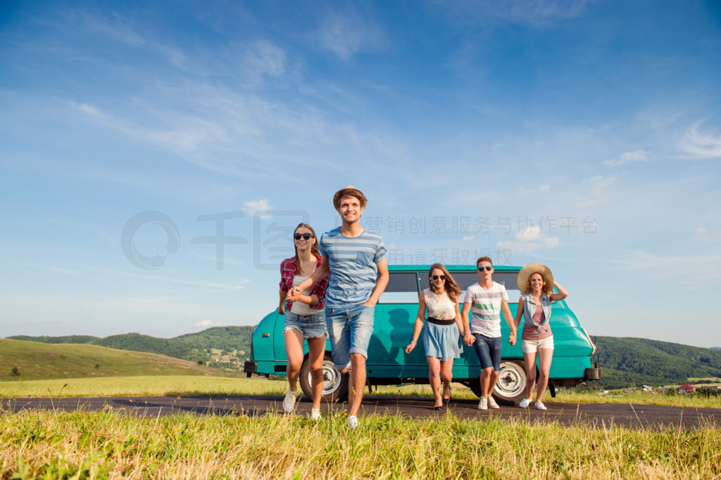 Running teenage couples in love outside against blue sky