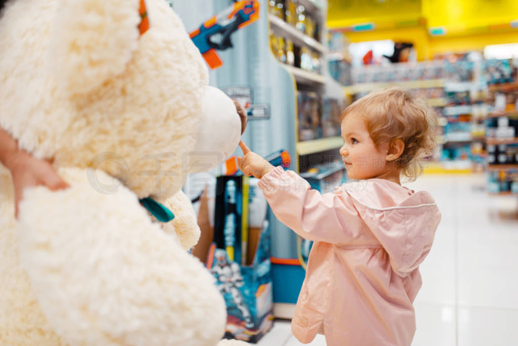 Girl高清图片 Little Girl Choosing Big Teddy Bear In Kids Store, Side View 