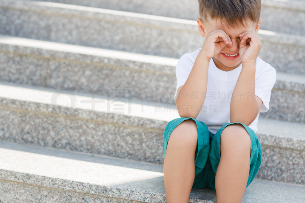 The boy sitting on the stairs in the underpass