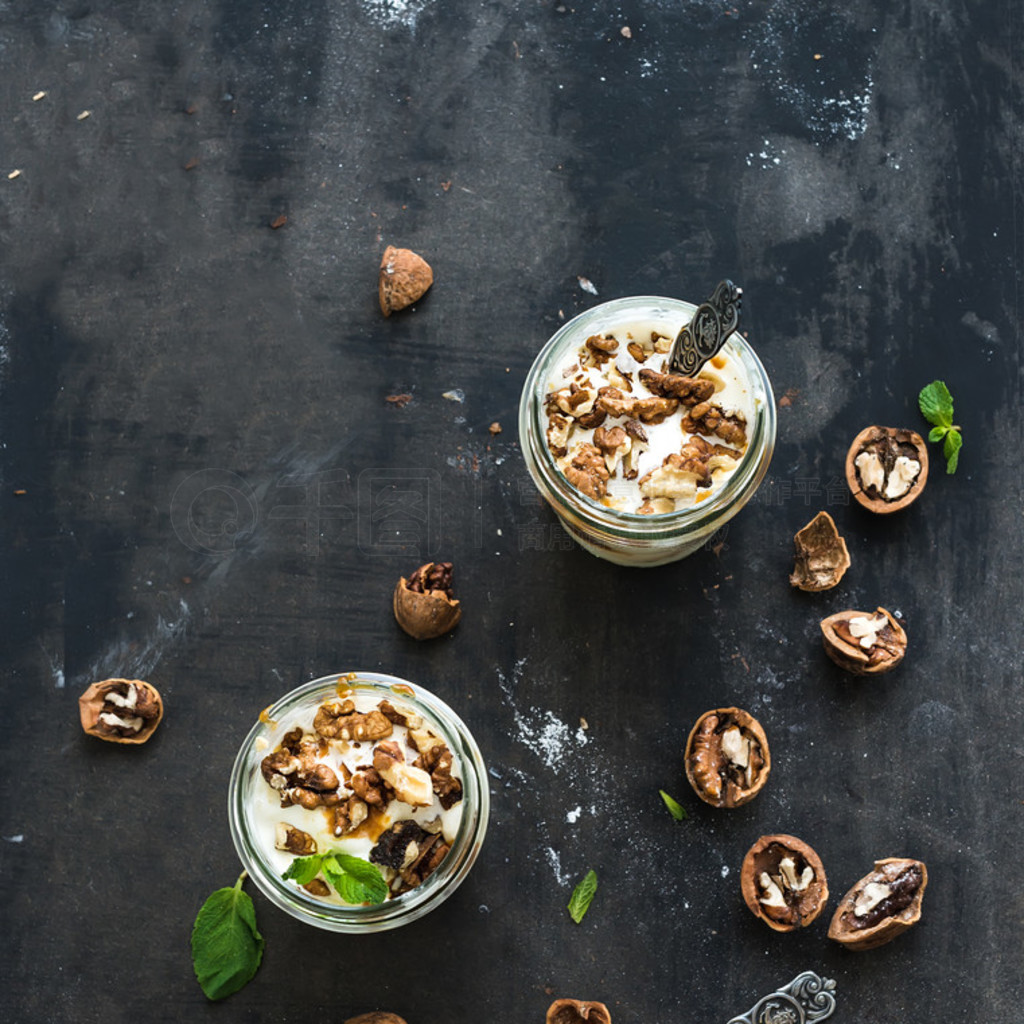 Walnut and salted caramel ice-cream in glass jars with fresh mint over dark grunge backdrop, top vie