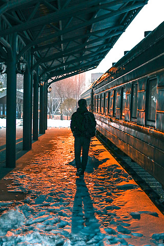 傍晚男人在火车站台行走的背影