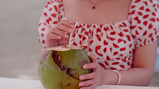 实拍夏季标<i>志</i>性场景女孩在海边喝椰汁画面