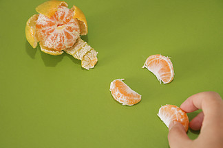桔子<i>剥</i><i>皮</i>水果美食桔瓣橘子绿色生动海报背景