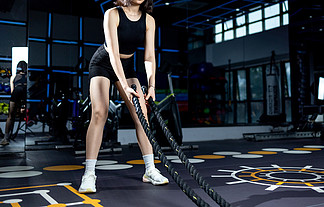 健身房拿着绳子锻炼臂力的女性