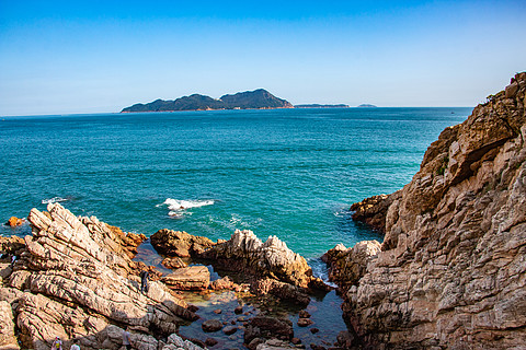 蓝色天空近景礁石远景小岛海面水平面海平面