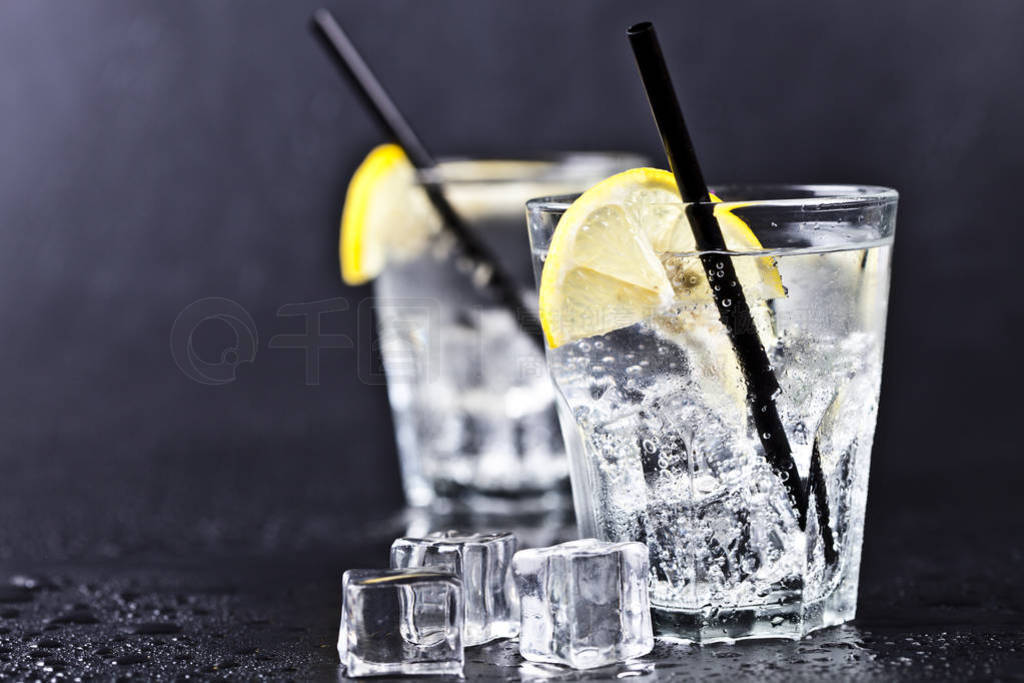 Glasses of fresh cold carbonated water with ice cubes and lemon