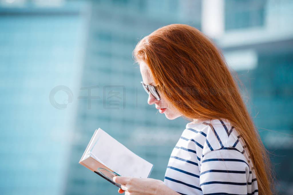 Smiling beautiful woman in a light coat against the backdrop of