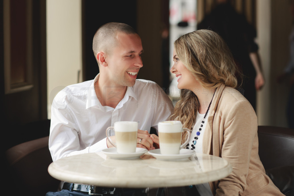 Happy couple drinking coffee in an urban caf.