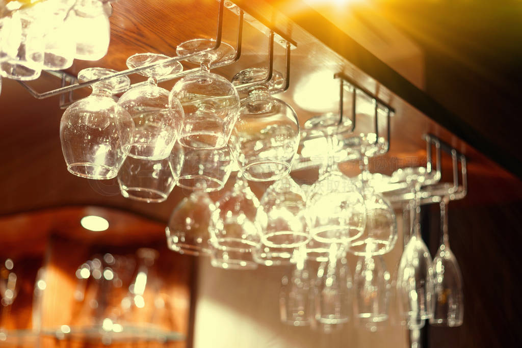 Empty glasses hanging above the bar in the restaurant.