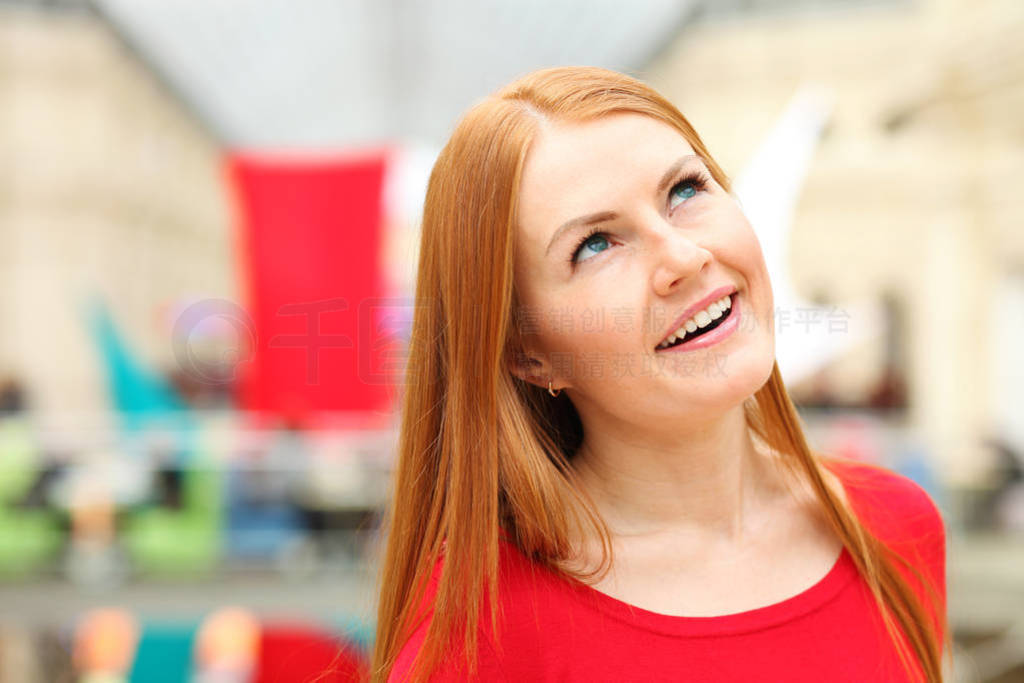 Portrait of a young red-haired woman in a red jumper