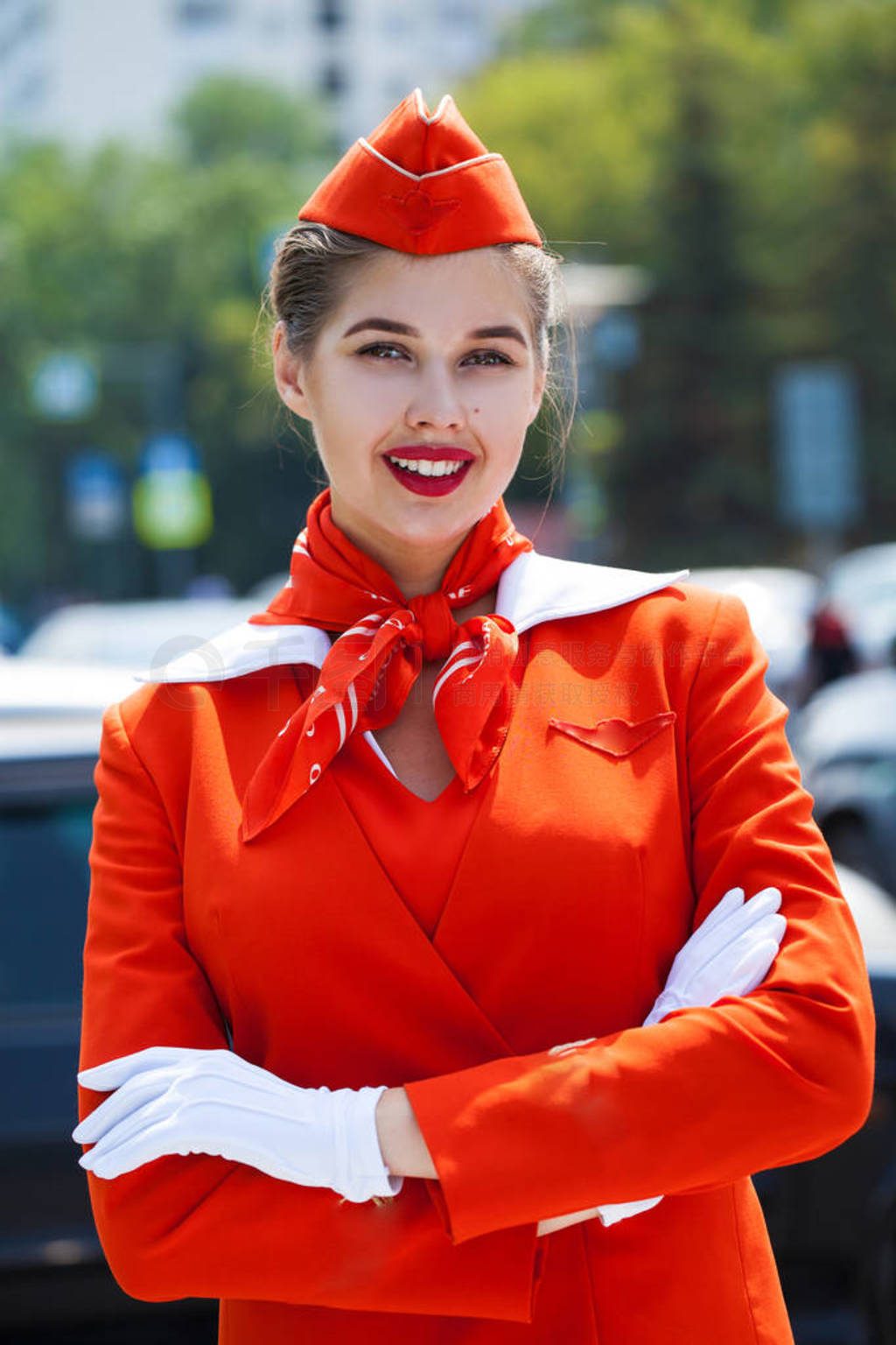 Young stewardess dressed in official red uniform of Airlines