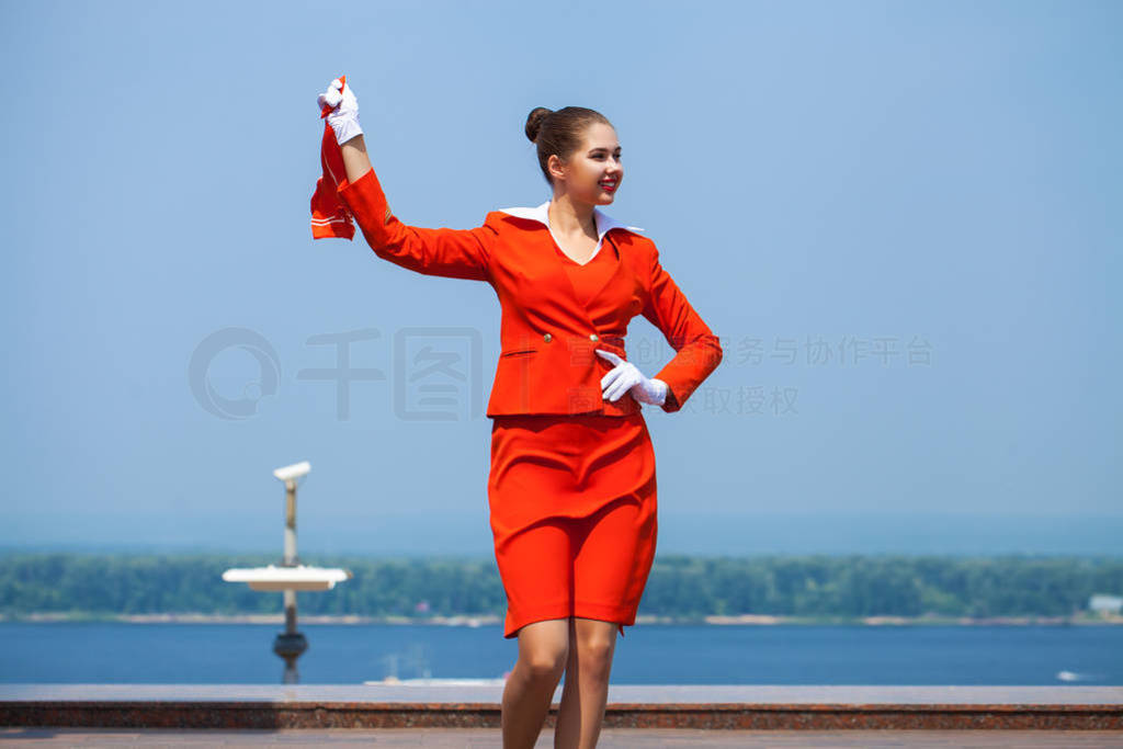 Young stewardess dressed in official red uniform of Airlines