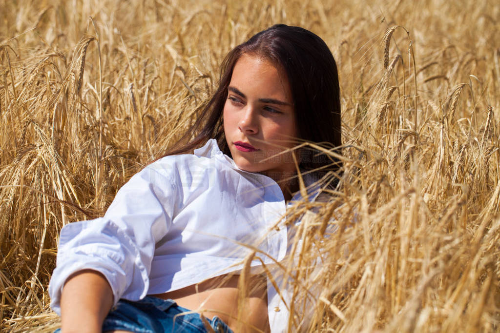 Young brunette woman in white shirt and blue jeans shorts