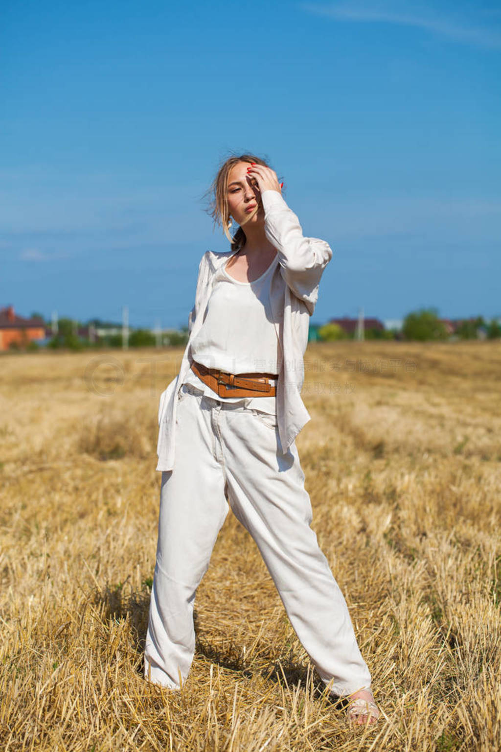 Young beautiful blonde woman in a beige suit posing against the