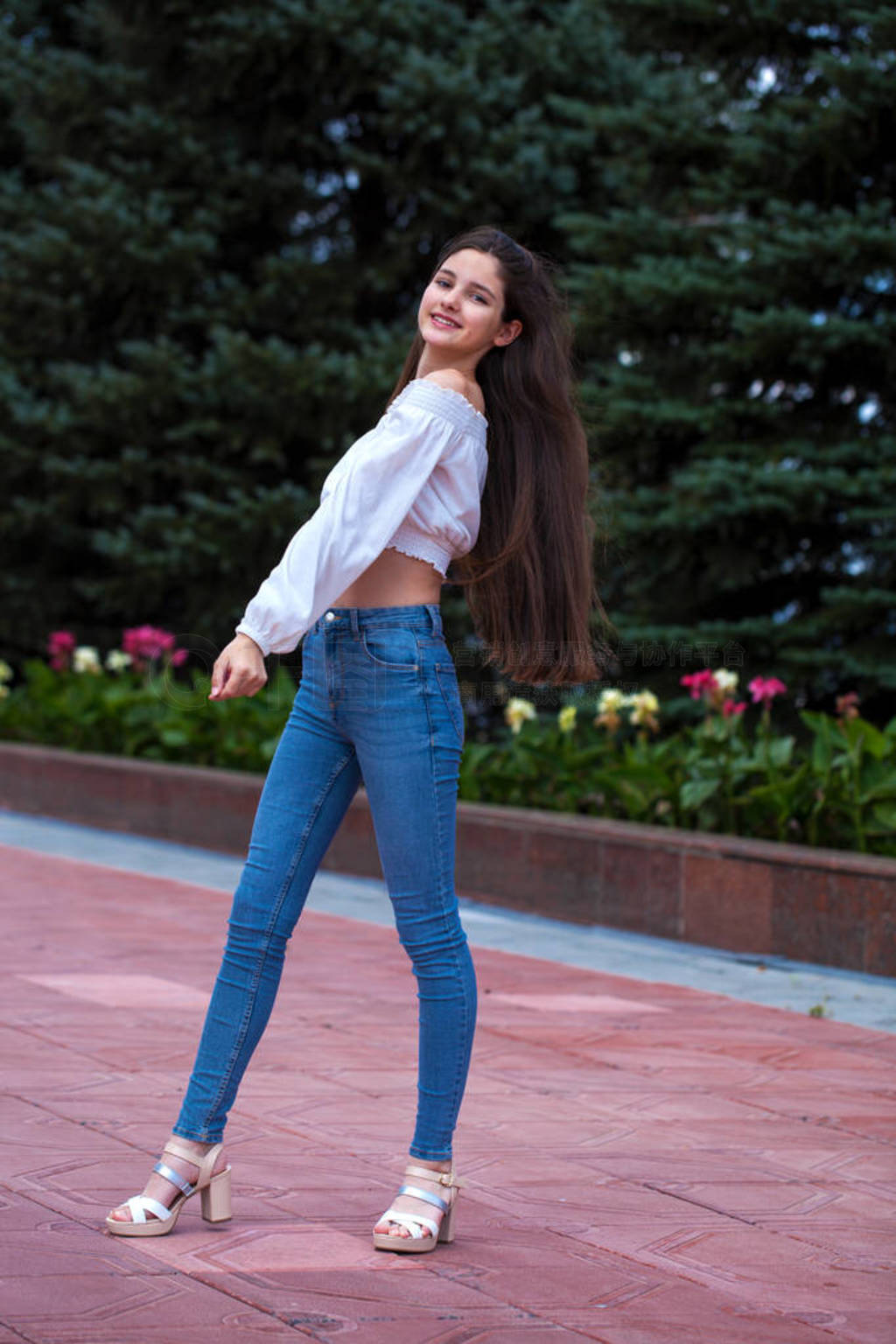 Pretty stylish brunette girl in blue jeans and white blouse