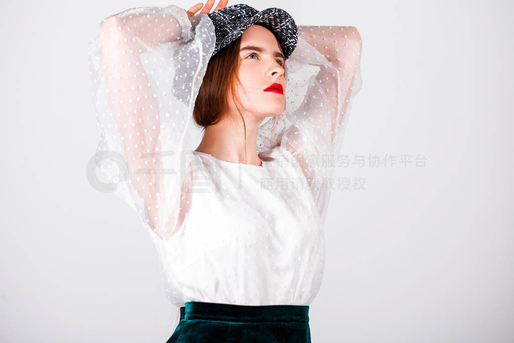 Portrait of a young brunette woman in a white blouse