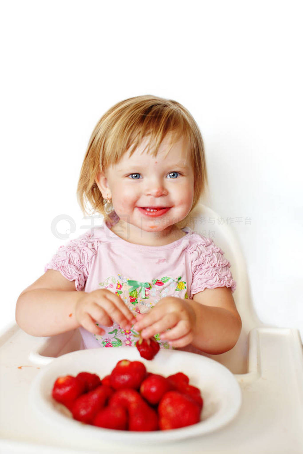 baby girl eating strawberry