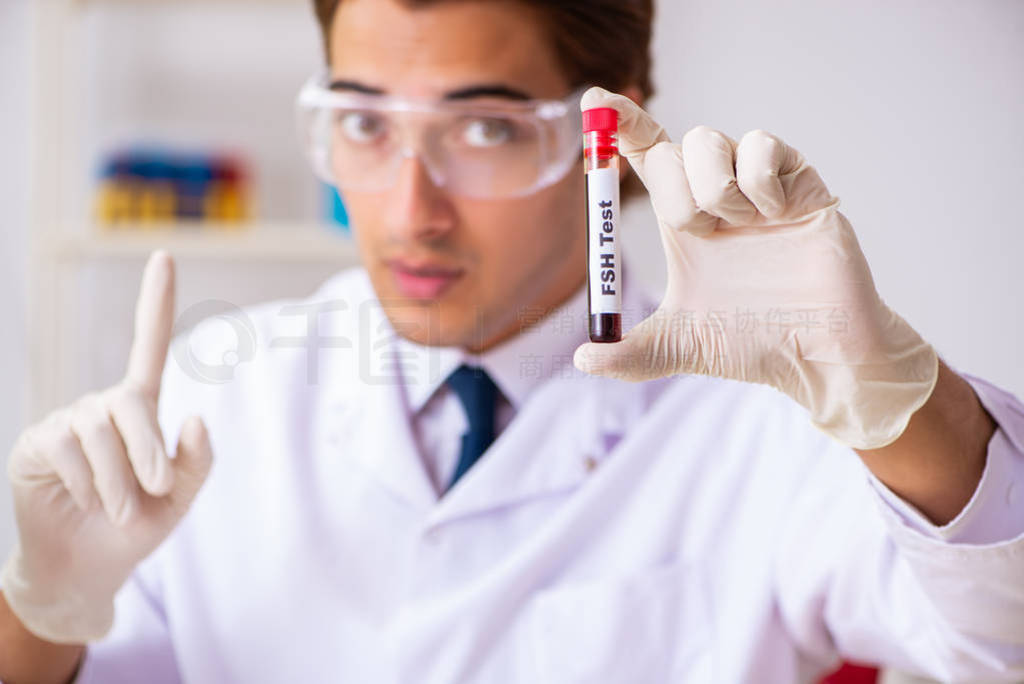 Young handsome lab assistant testing blood samples in hospital