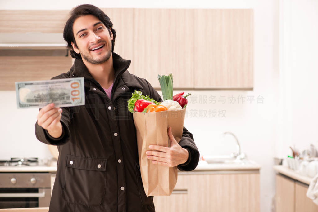 Young handsome man with vegetables in the kitchen