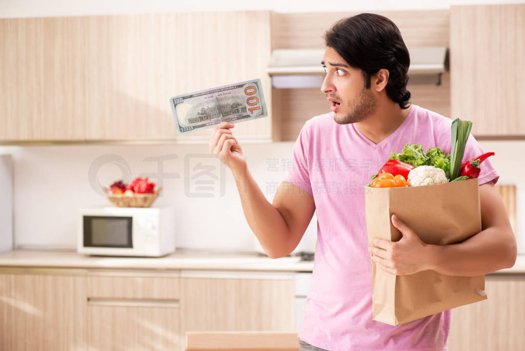 Young handsome man with vegetables in the kitchen