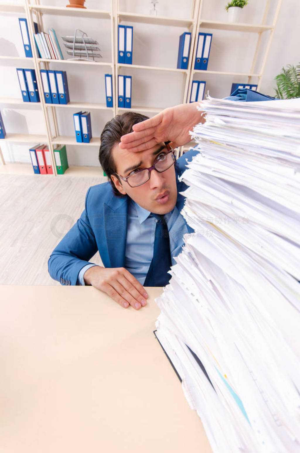 Young handsome businessman unhappy with excessive work