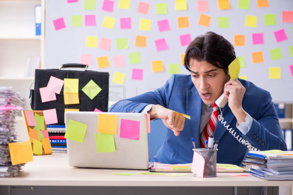 Young male handsome employee in conflicting priorities concept