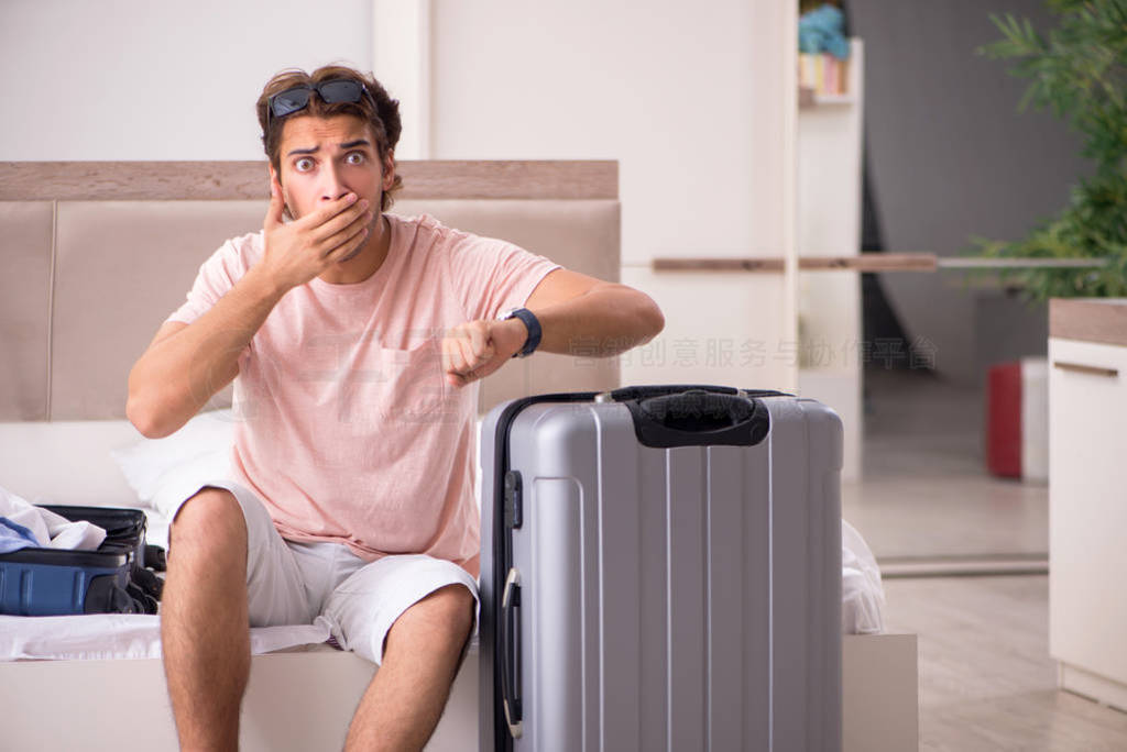 Man with suitcase in bedroom waiting for trip