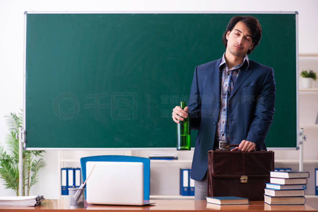 Male teacher drinking in the classroom