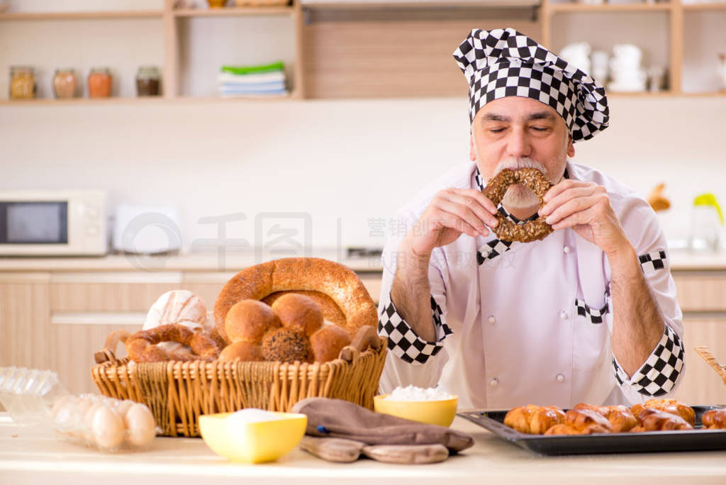 Old male baker working in the kitchen