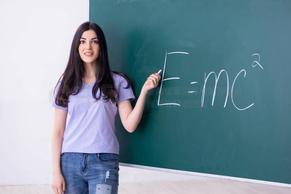 Young female teacher student in front of green board