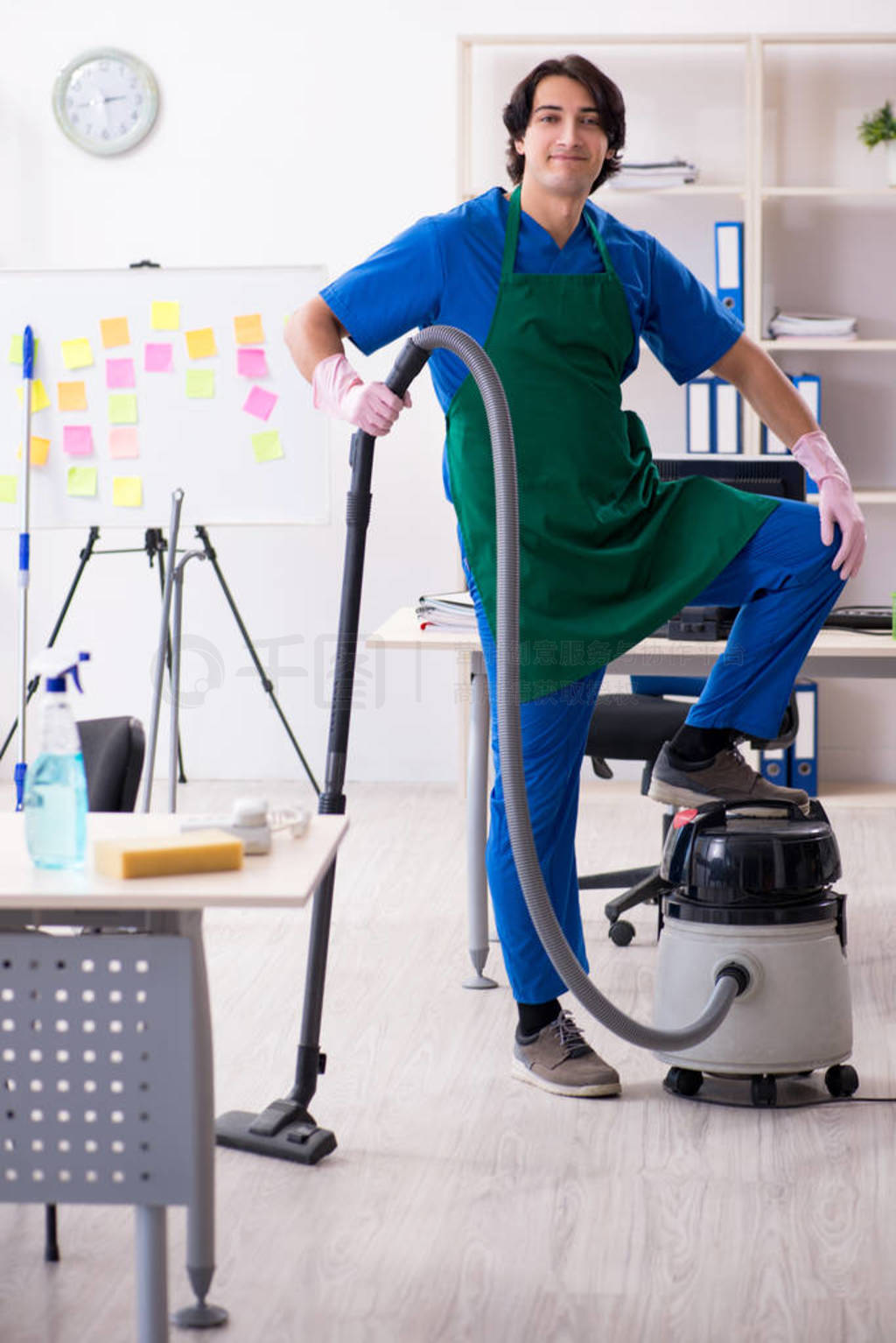 Male handsome professional cleaner working in the office