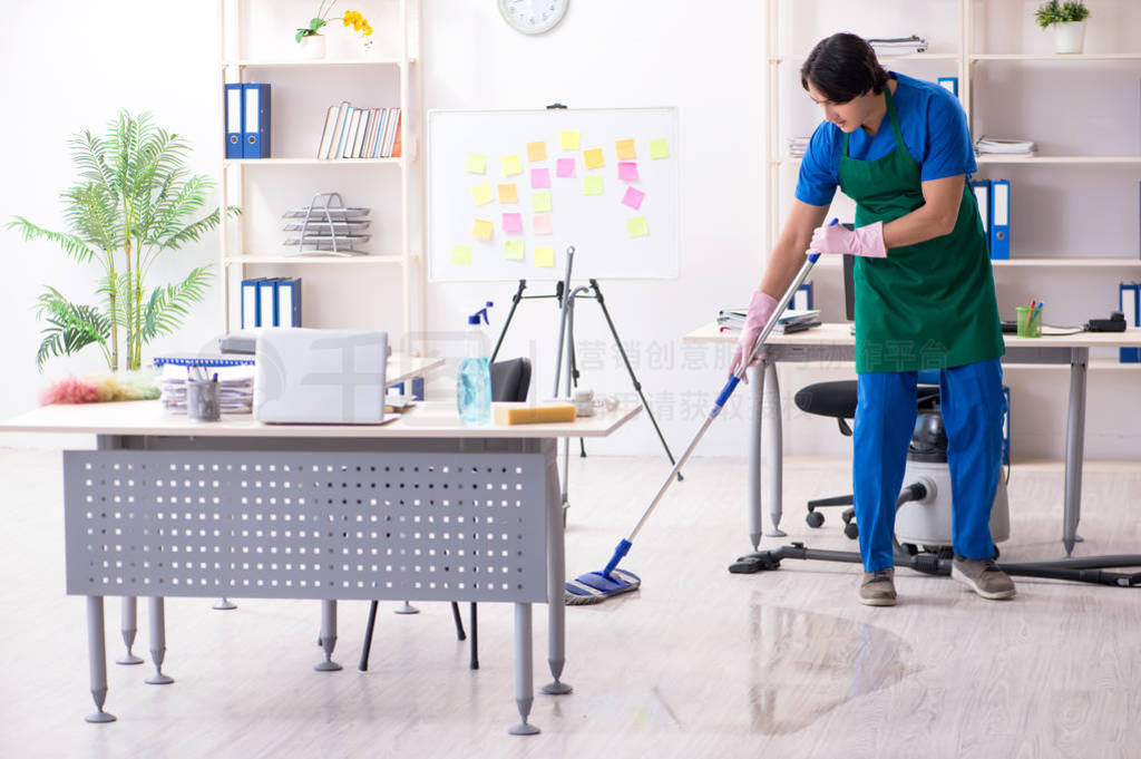 Male handsome professional cleaner working in the office