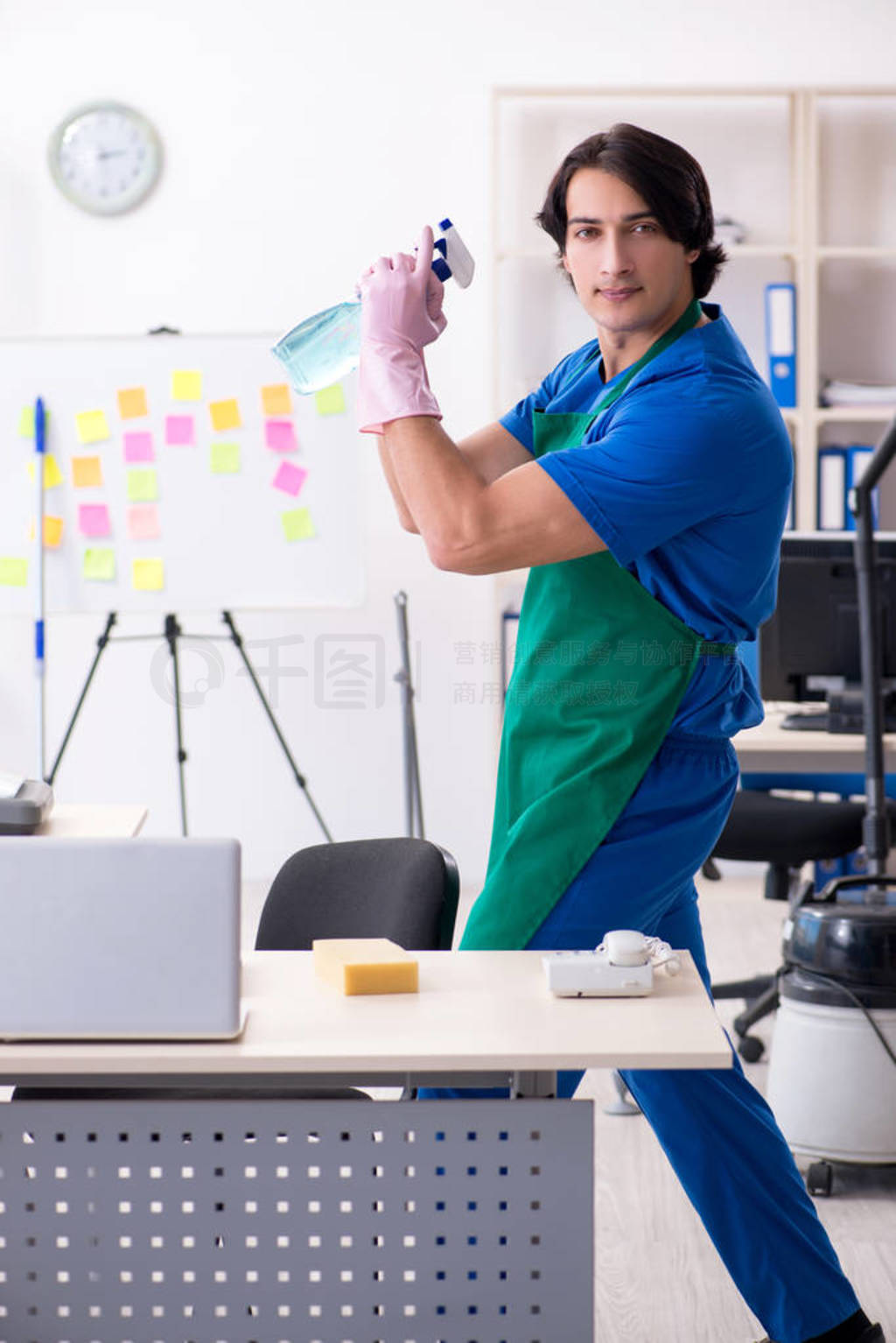 Male handsome professional cleaner working in the office