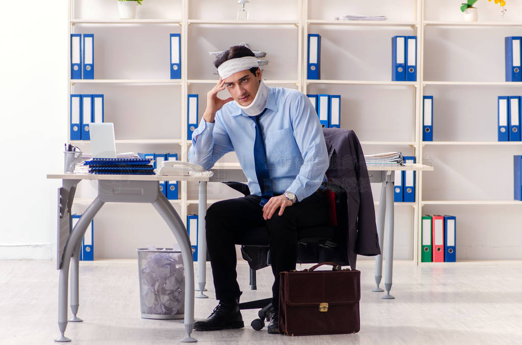 Young injured male employee working in the office