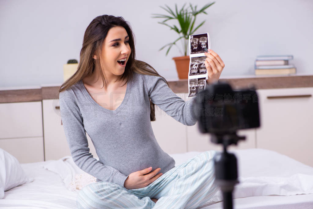 Pregnant woman recording video for her blog