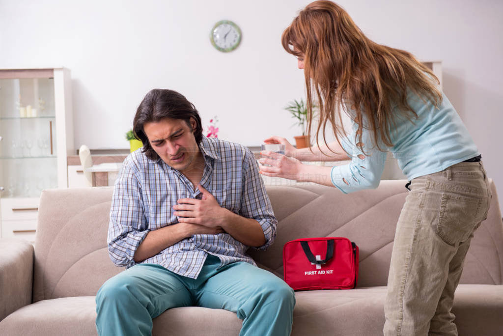 Young couple in first aid concept at home