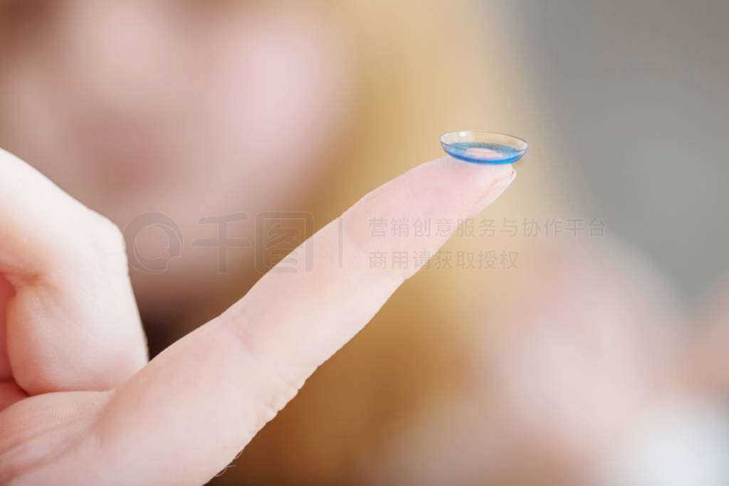 blue eye lens on finger