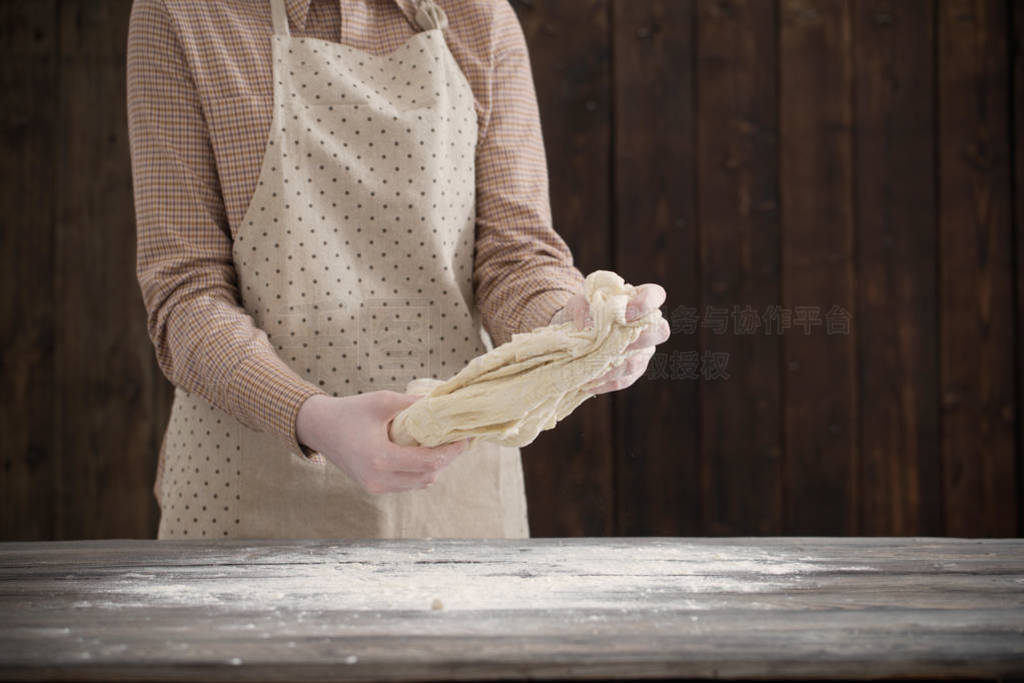 hands cooking dough on dark wooden background