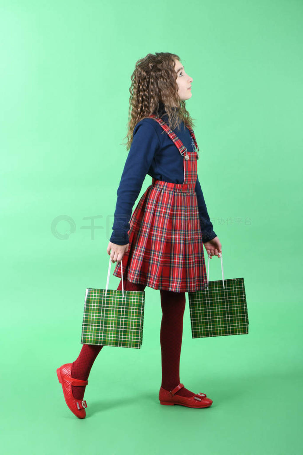 Child with a green packaging checkered texture isolated on green